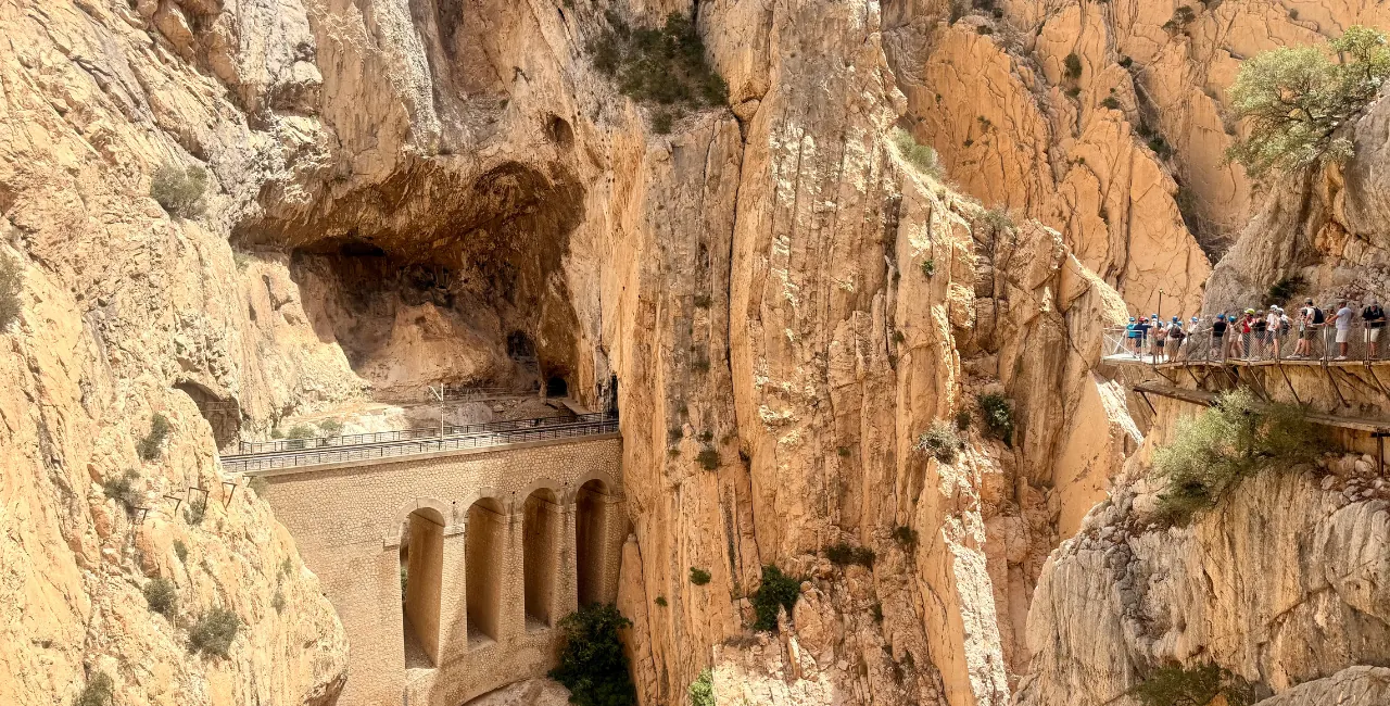 Desfiladero con un viaducto de piedra y visitantes recorriendo la pasarela