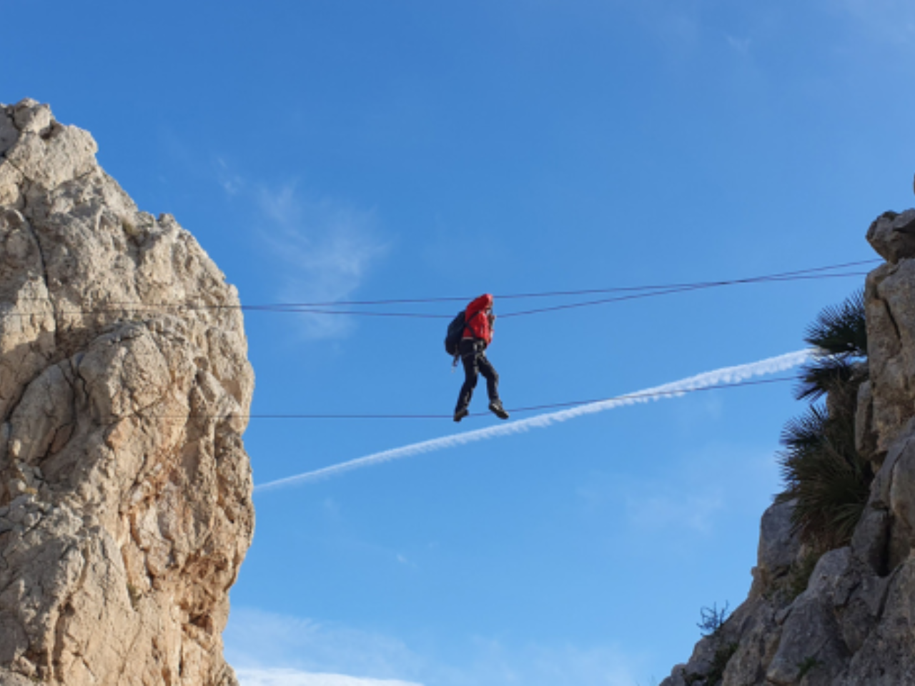 Participantes ascendiendo por la pared rocosa con material de vía ferrata